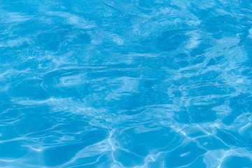 Blue pool water with sun reflections