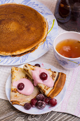 pancakes with yogurt and cherries on a wooden table