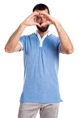 Fototapeta premium Man with blue shirt making a heart with his hands