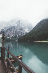 Braies lake with wood building and mountains with trees - 121590394