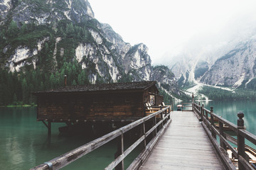 wooden jetty on Braies lake with mountains and trees
