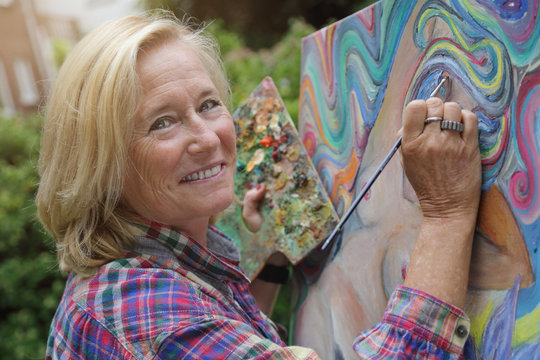 femme senior artiste peintre peignant tableau en peinture &agrave; l'huile en ext&eacute;rieur