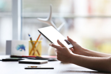 Woman's hands using tablet at the table