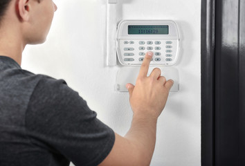 Man pressing the code on a house alarm