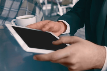 Businessman with tablet in cafe