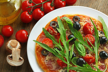 Tasty pizza with vegetables, herbs on wooden background
