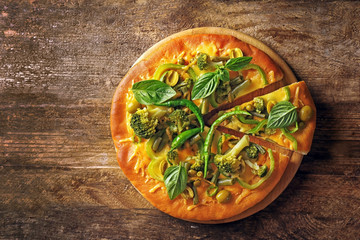 Tasty vegetarian pizza on wooden background