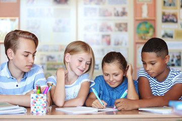Cute schoolchildren in classroom on lesson