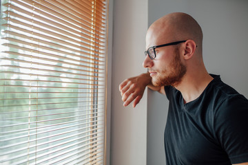 Young man is looking out the window.