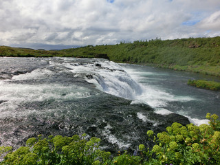 Faxi waterfall flowing in Icelandic countryside