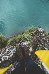 Legs and foot of a man with yellow raincoat on the top of a cliff on Braies lake - 121595195