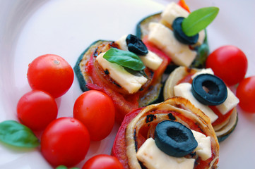 Grilled zucchini slices with tomatoes, black olives, goat cheese and basil
