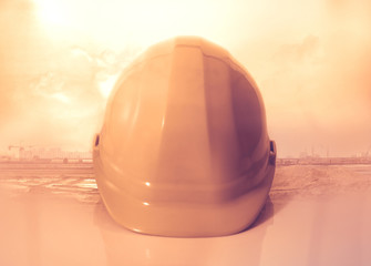 Fototapeta na wymiar Safety hat / Yellow safety hat on construction site background. Protection devices for industrial applications. Vintage style.