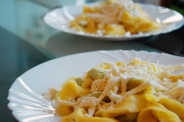 Ravioli filled with spinach and ricotta, Italian egg pasta, with fresh goat cheese on top