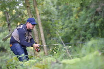 Fisherman fishing in river from riverbanks