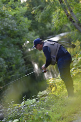 Fisherman fishing in river from riverbanks
