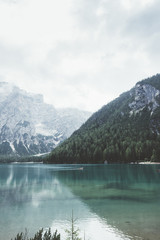 Braies lake with green water and mountains with trees - 121596750