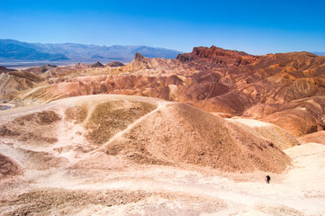 Mann holt einen weggeflogenen rosafarbenen Hut im Death Valley zurück
