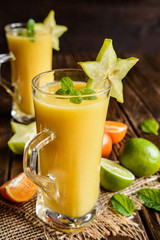 Mandarin smoothie with carambola and lime in a glass jar