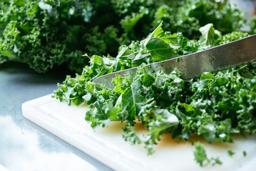 Kale being sliced on a cutting board