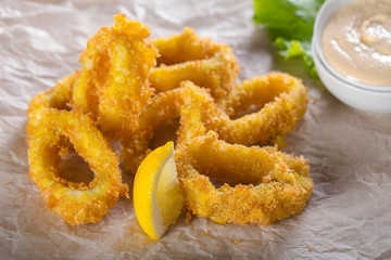Fried squid rings with lemon and sauce