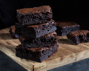 Chocolate brownie on the black background, side view, selective focu
