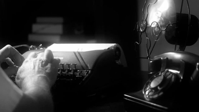 Dimly lit Film Noir setting of a man typing on a 1940 manual typewriter with an old electric fan and classic teacup and saucer close by.