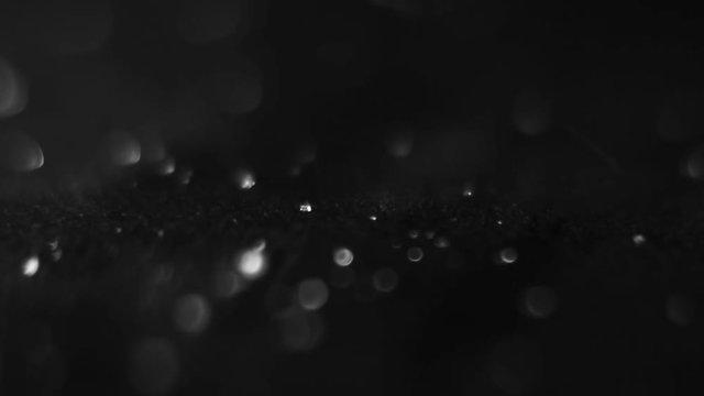 Tiny little white crystals drops on a black surface
