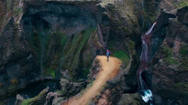 Man with raised hands up feeling freedom while standing at Fjadrargljufur canyon in Iceland