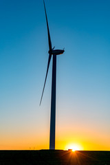 Fototapeta na wymiar Sunset above windmill on the field