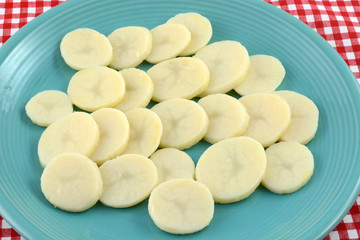 Canned rinsed potato slices on blue plate