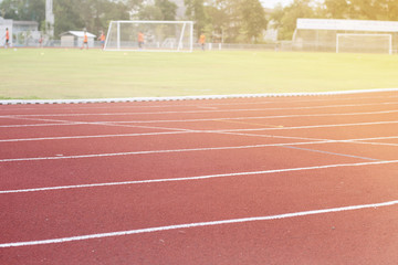 Fototapeta premium Running track around the football field with the evening sun