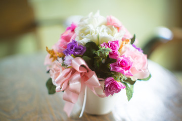 Beautiful flowers in vase on table in room  (old lens effect)