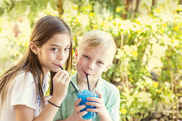 Cute kids sharing a delicious flavored ice drink together