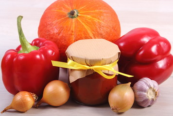 Sauce of pumpkin in glass jar and ingredients on wooden table