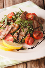 Straccetti Grilled beef with arugula and tomatoes close-up. vertical

