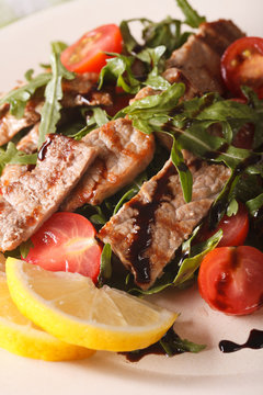 Warm salad of grilled beef with arugula and tomatoes macro. vertical
