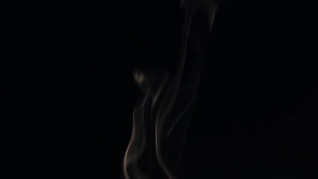 Beautiful wisp of smoke on a black background. Warm tone