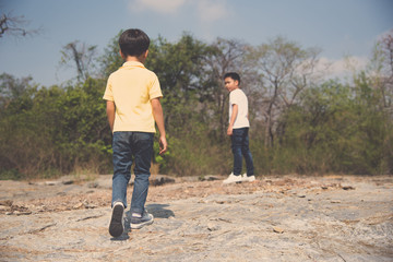 Obraz na płótnie Canvas Two Boy walking on the rocky land.