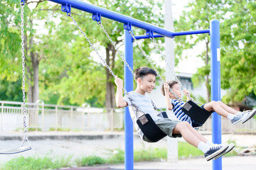 Asian boy play with swinging.