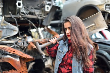Fototapeta na wymiar long-haired brunette girl posing in a car scrappage