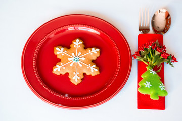 Christmas background - elegant red plate with cookies and spoon, fork, knife.