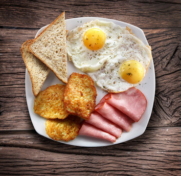 Breakfast - fried eggs with ham and pieces of bread.