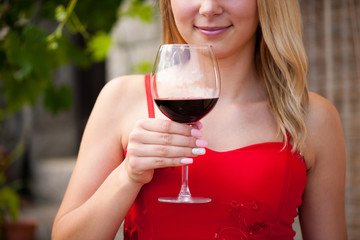Beautiful woman drinks red wine outdoor on a hot summer afternoo