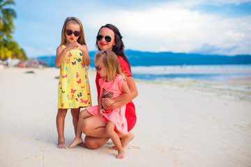 Fototapeta premium Mother and two her kids at exotic beach on sunset