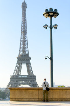 Old man tourist taking picture of Tour eiffel