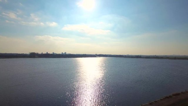 Nice lake with sun on the horizon filmed with a drone