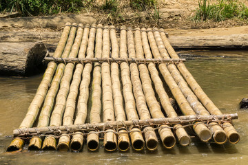 Bamboo raft and worn timber log on a river bank at Kota Marudu, Sabah, Malaysia