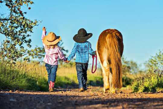 Little cowgirl and cowboy with pony
