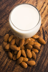 Almond milk with almond on a wooden table